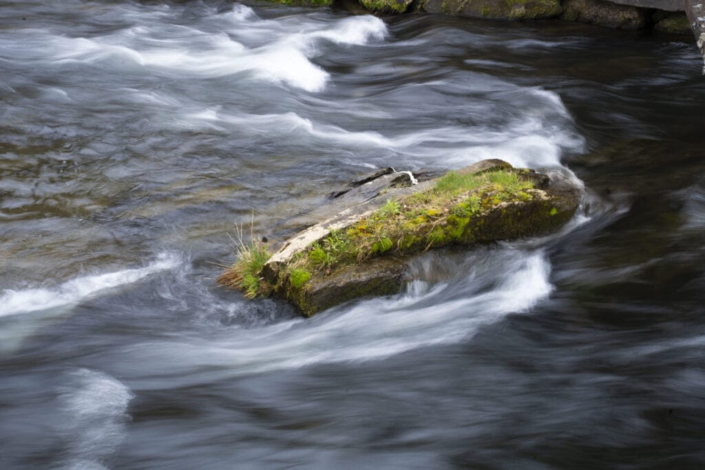 Water in a stream flowing around a rock