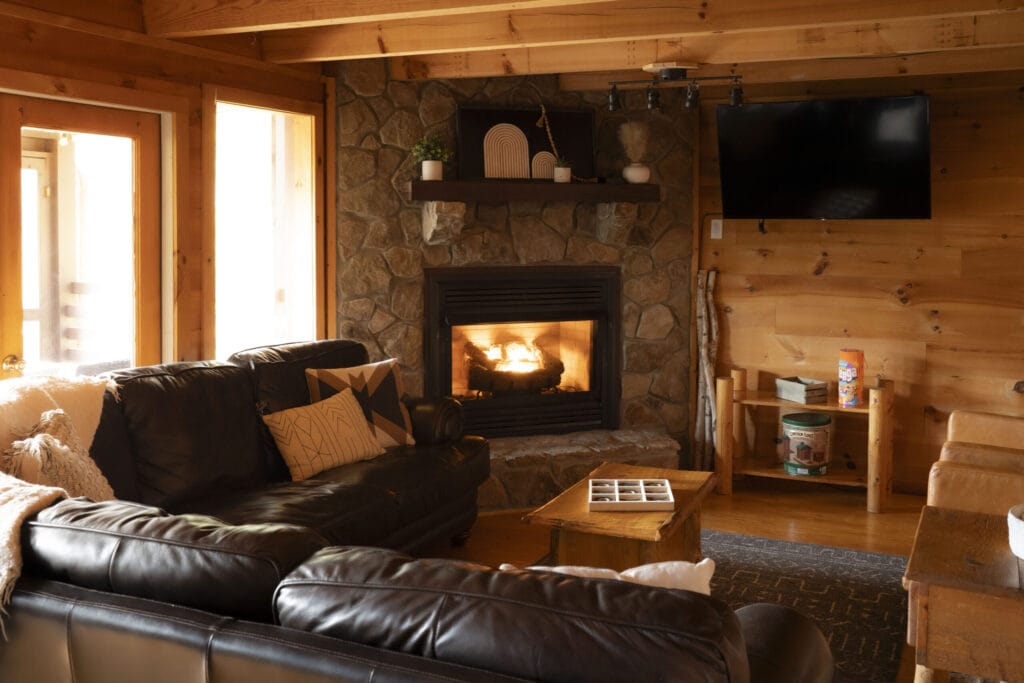 living room with a sofa, tv, and fireplace in the Lincoln Logs Cabin